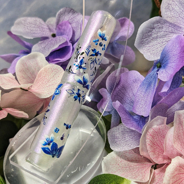 Decorative pen with floral design on a bed of pink and purple flowers