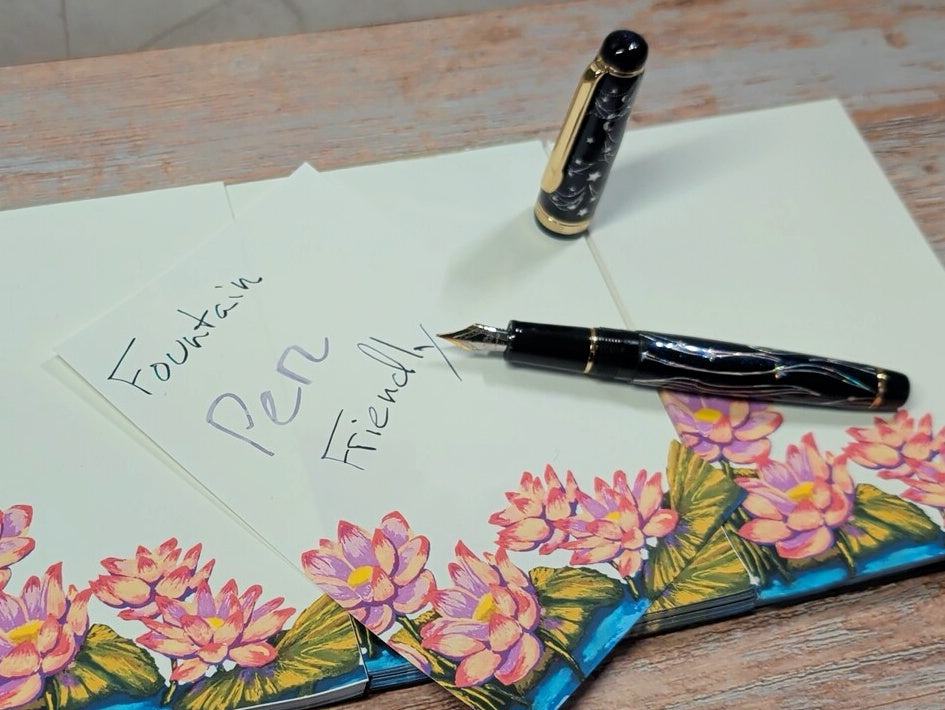 Fountain pen and letter with floral design on a wooden surface