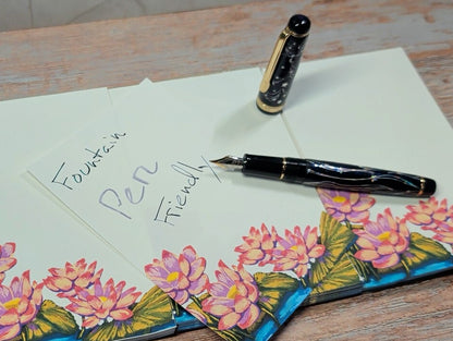 Fountain pen and letter with floral design on a wooden surface